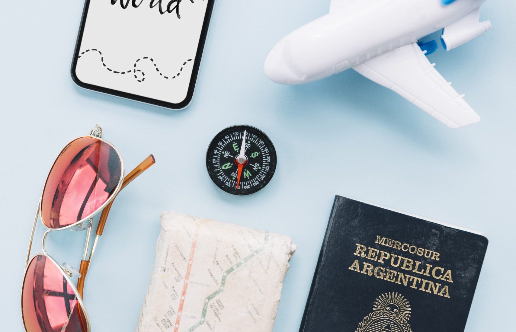 travel-world-message-smartphone-with-sunglasses-wrist-watch-map-passport-compass-toy-airplane